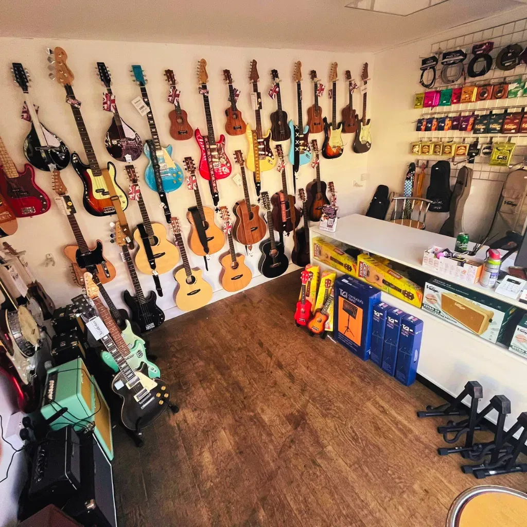 Instruments, including guitars and ukuleles, displayed in the DeRosa Music Buntingford shop
